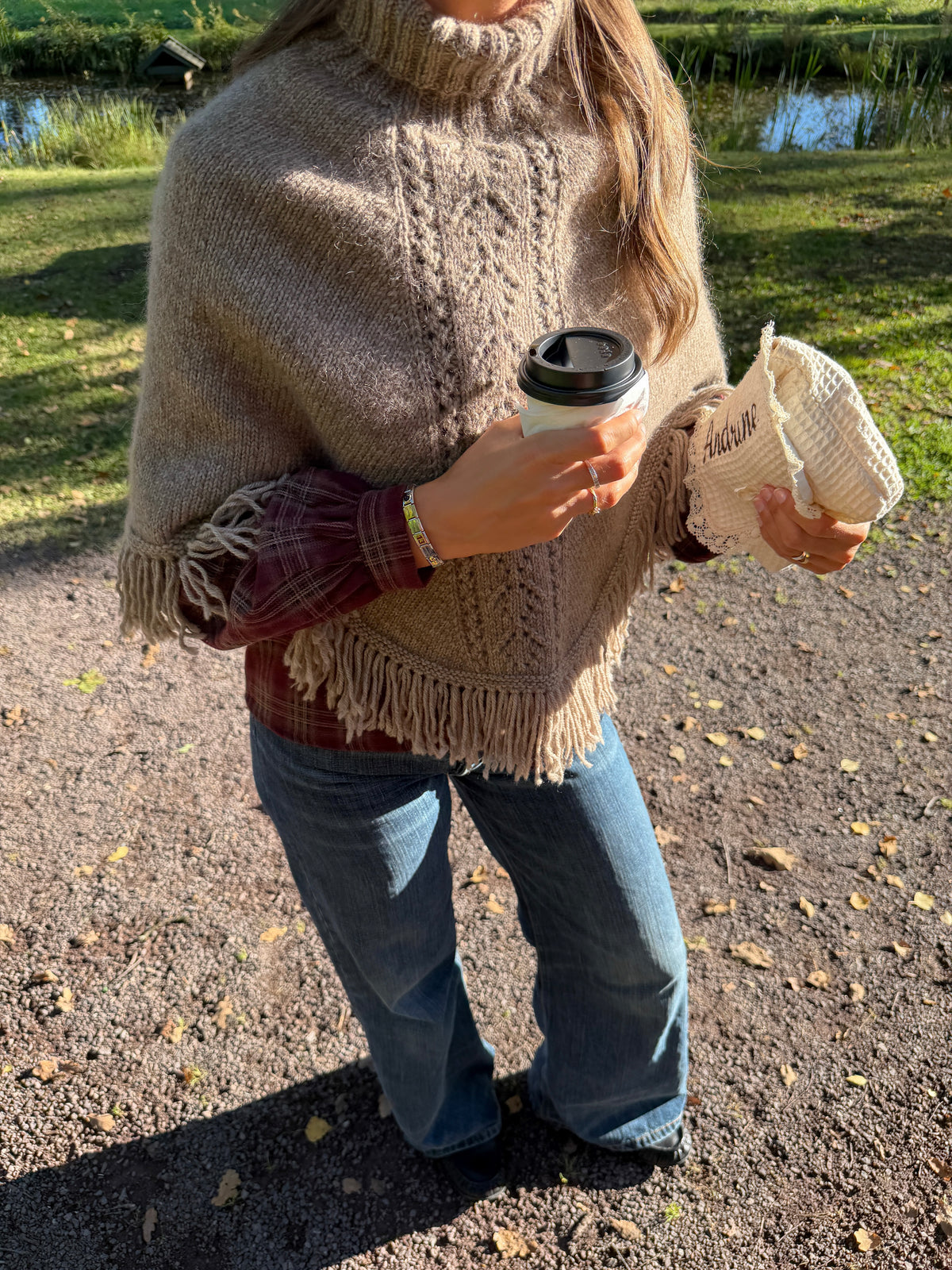 The Jolie Poncho on a park bench among fallen leaves